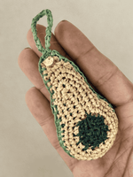 Load image into Gallery viewer, Avocado raffia charm in hand, green tones and pit detail