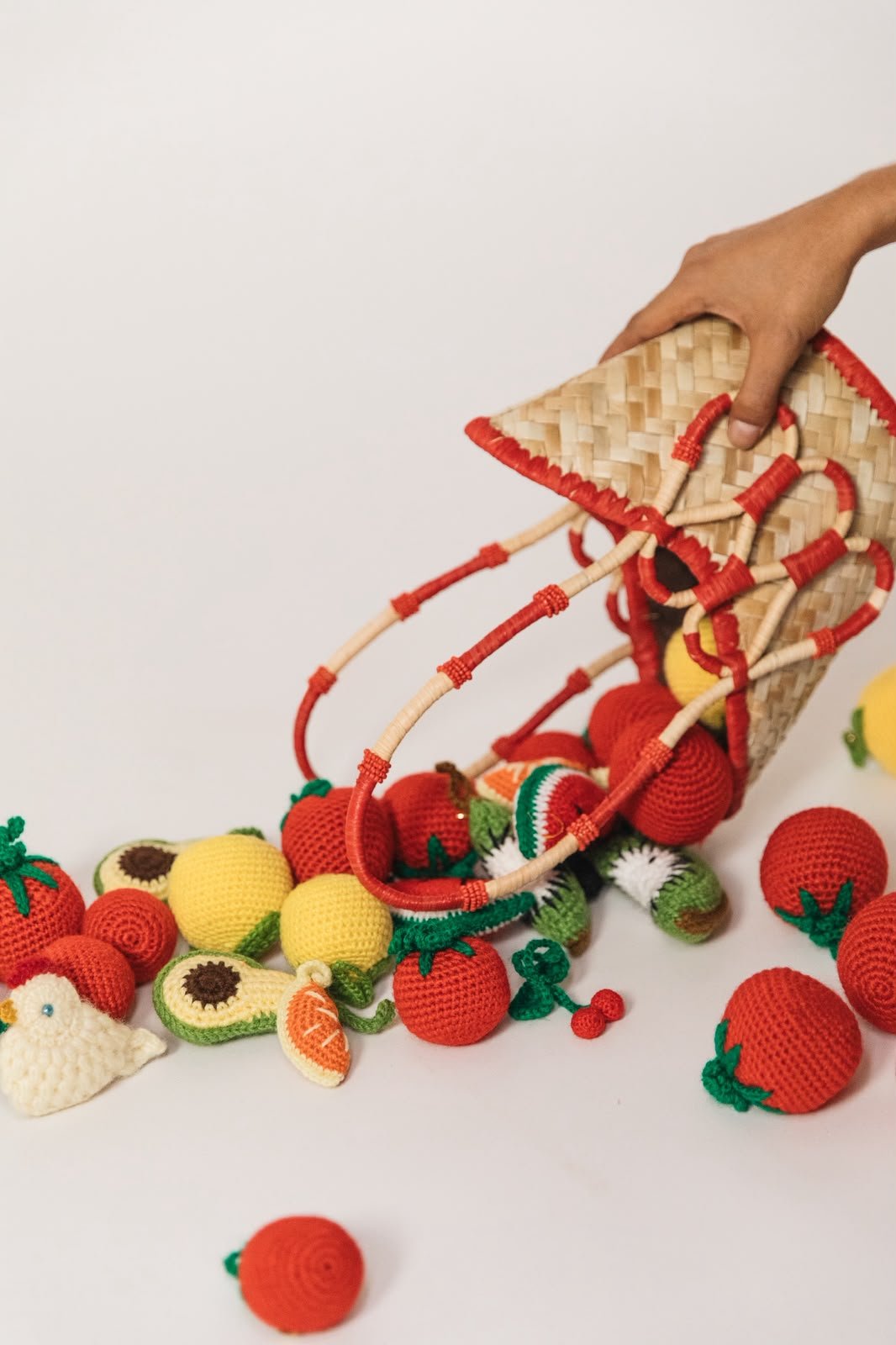 Panier et assortiment de charms fruits en raffia disposés au sol