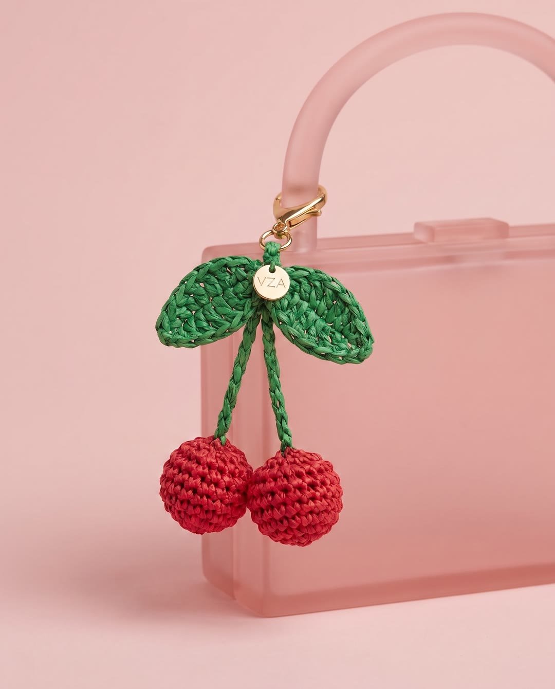 Charm cerises en raphia YZA porté sur un sac
