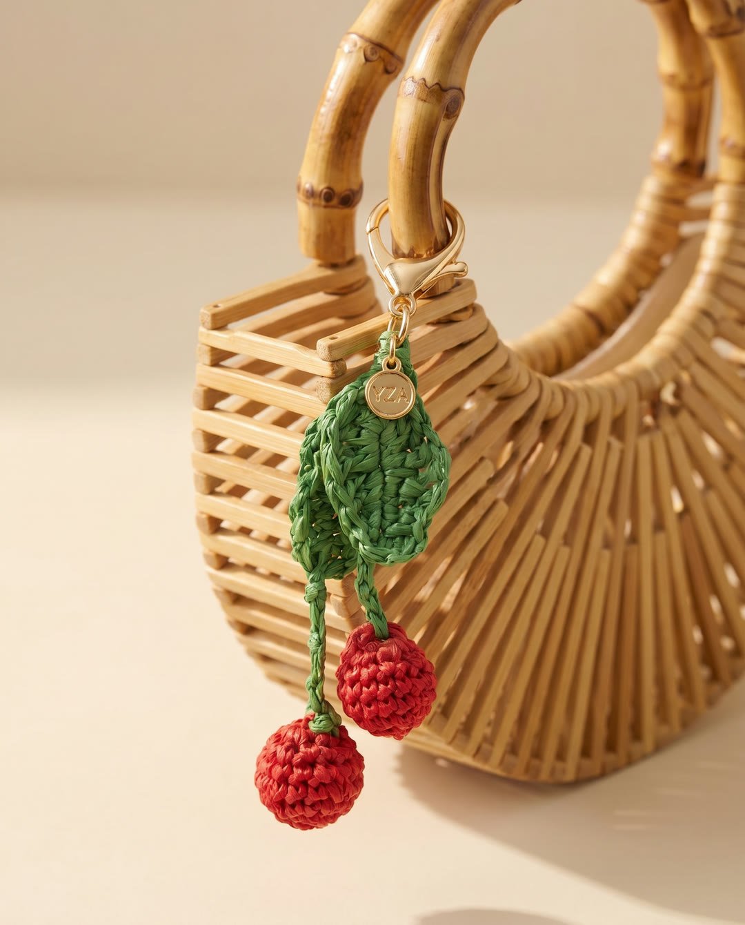 Charm cerise en raphia YZA porté sur un sac