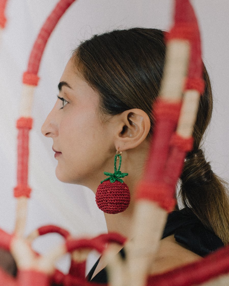 Profil encadré par les anses du panier YZA rouge, boucle d'oreille tomate crochetée
