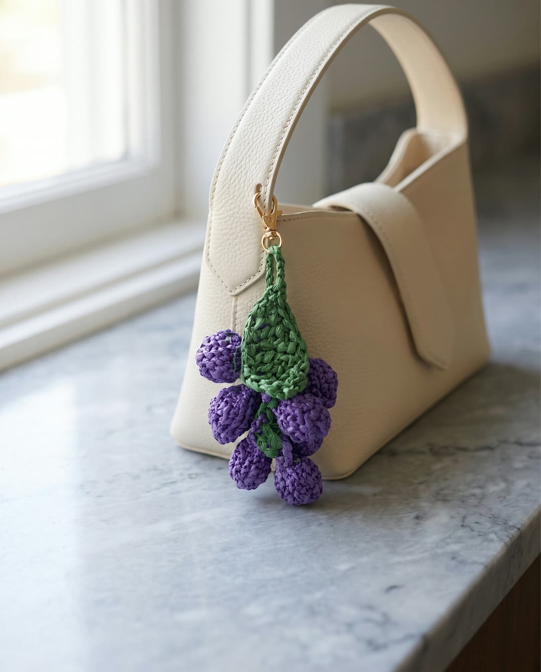 Charm raisin en raphia YZA porté sur un sac