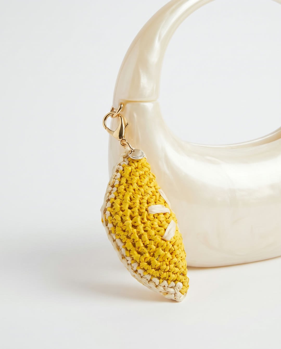 Charm citron en raphia YZA porté sur un sac