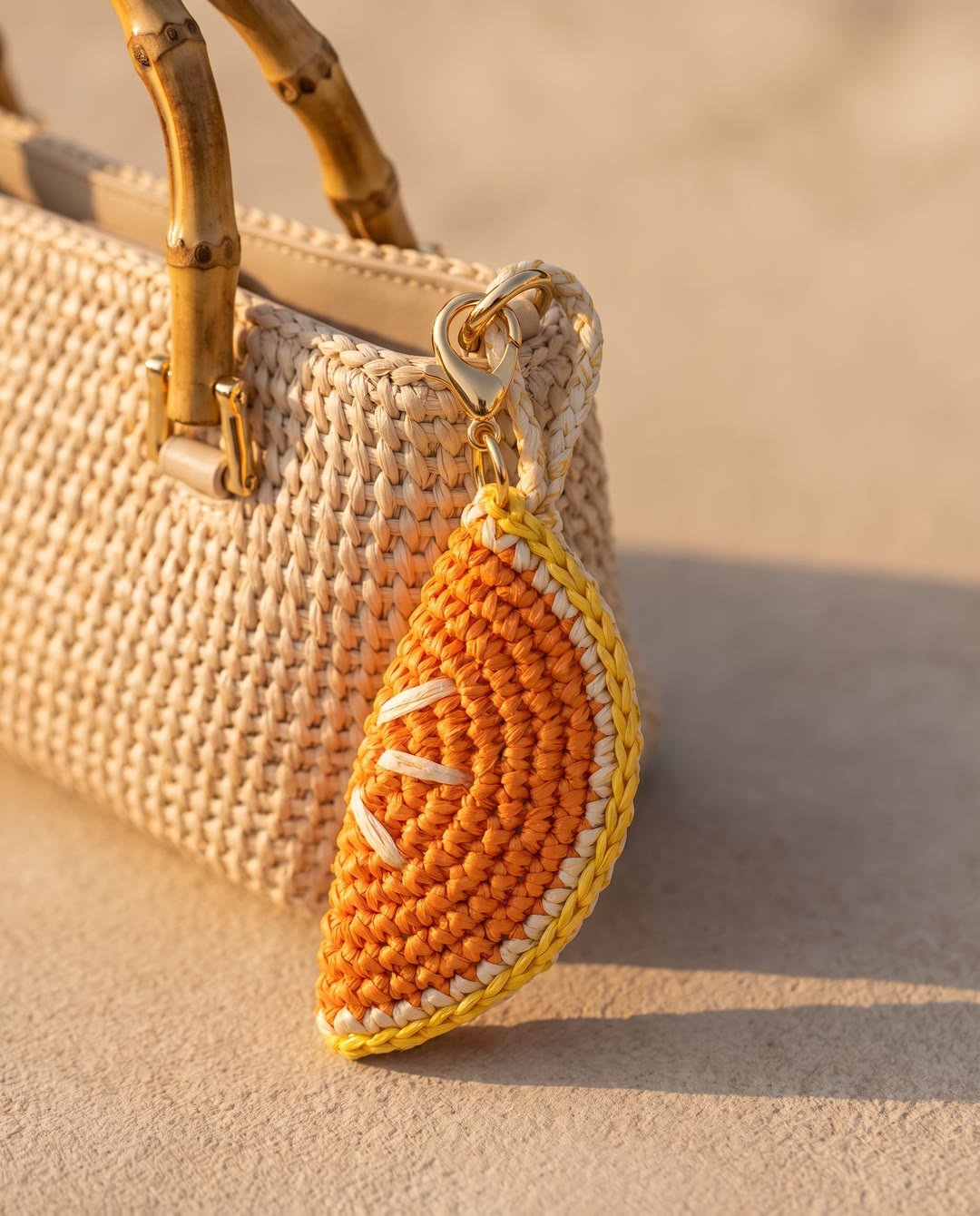 Charm orange en raphia YZA porté sur un sac