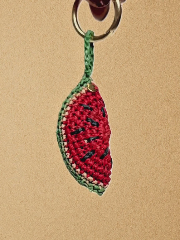 Short clip showing the Watermelon Slice charm clipped to a La Vague bag; 360° view and movement