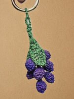 Load and play video in Gallery viewer, Purple Grapes charm shown in hand then on bag; focus on clustered crochet details
