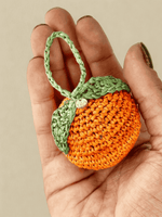 Load image into Gallery viewer, Orange raffia charm in hand, round shape and texture
